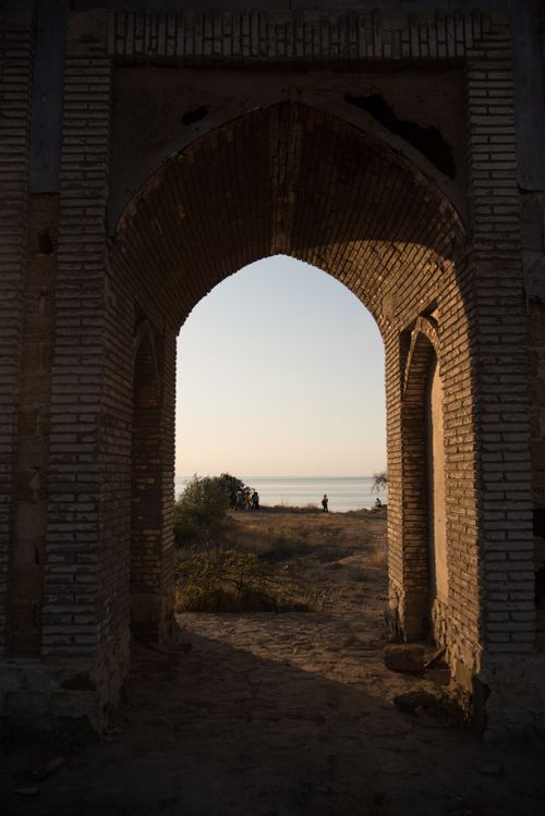 Free A timeless stone arch frames a calm seaside view, capturing the tranquil essence of early evening. Stock Photo
