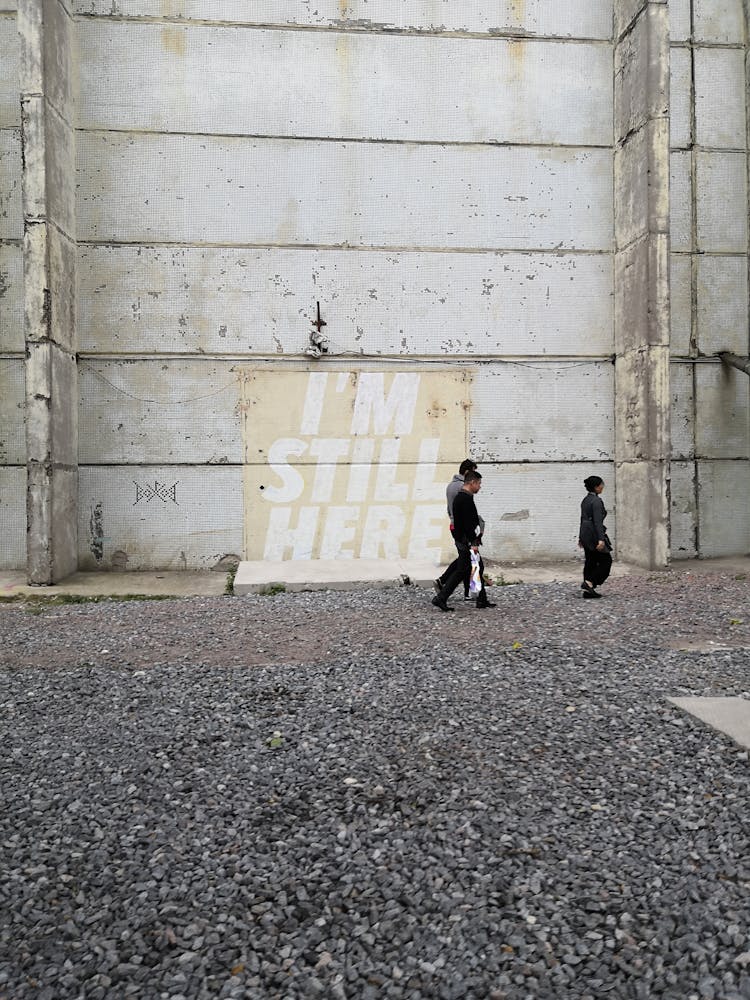 People Walking On Cobblestones Covered Ground