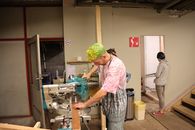 A Man with Dyed Hair Using a Miter Saw
