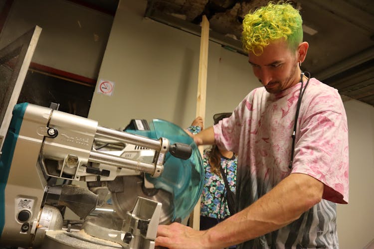 A Man Using A Miter Saw