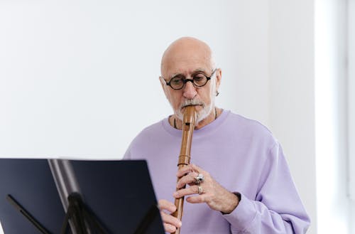 Man in Purple Long Sleeve Shirt Playing Flute
