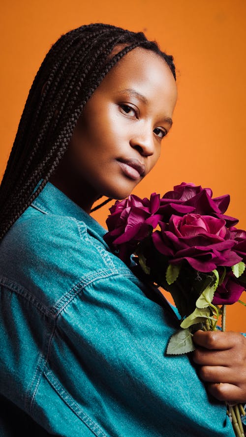 Woman in Blue Denim Jacket Holding Purple Flower