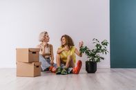 Woman in Black Tank Top Sitting on Brown Cardboard Box