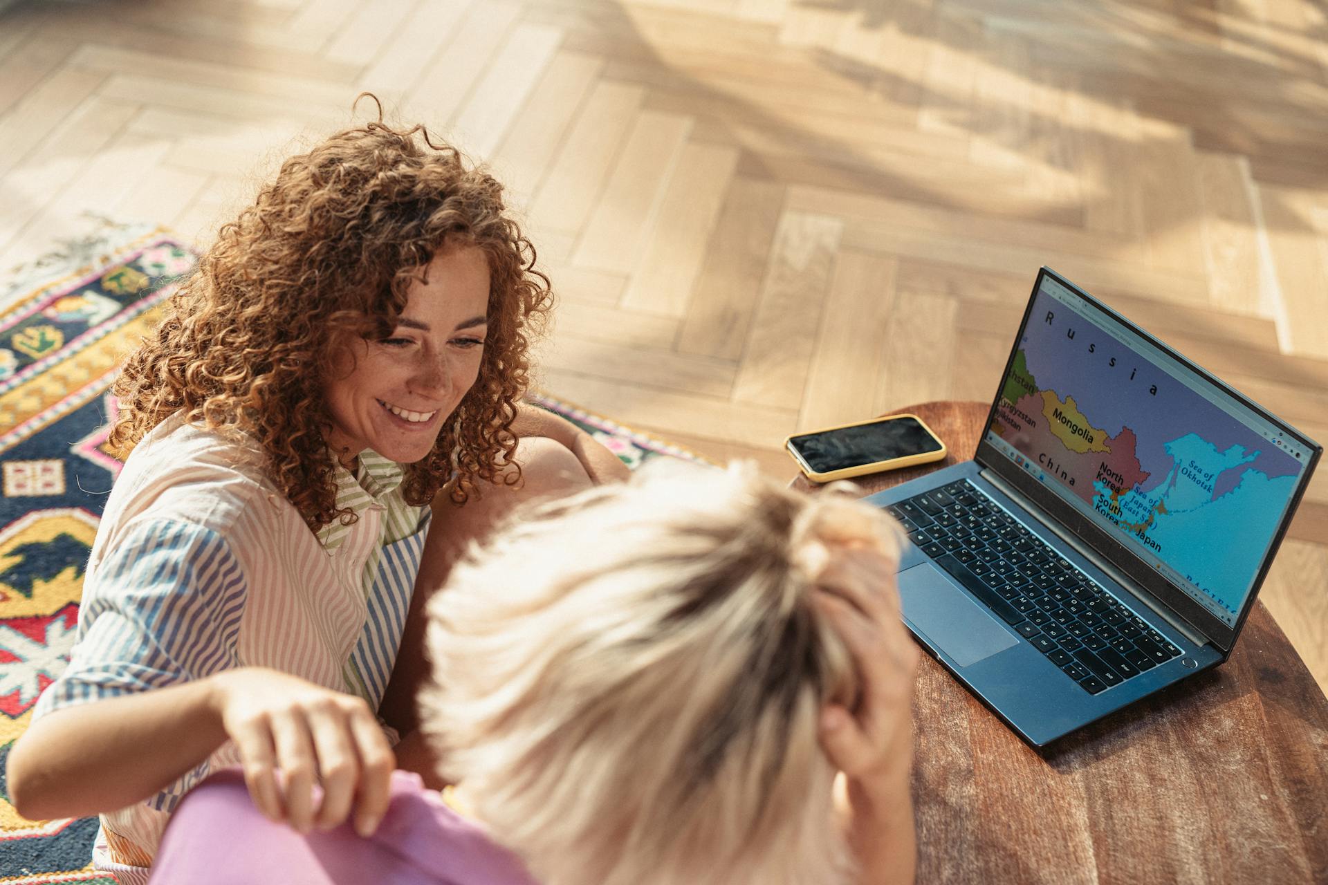 Two people explore a world map on a laptop, planning their next travel adventure.