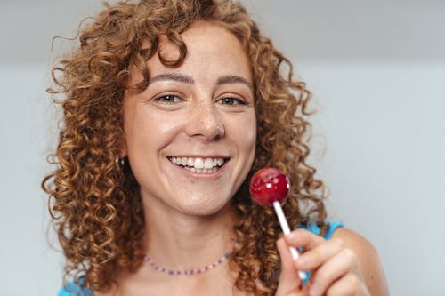Woman Holding Red Lollipop Smiling