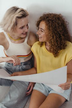 Two women sharing a joyful moment indoors, embracing happiness and connection.