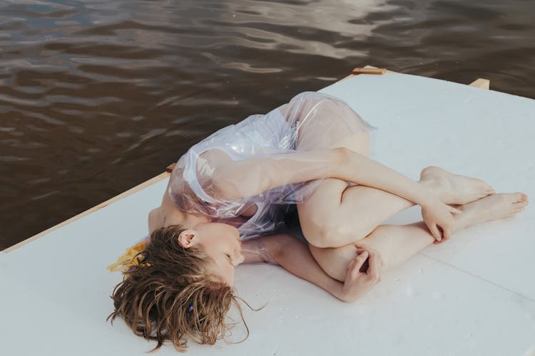 Wet Woman Lying On White Wooden Raft 