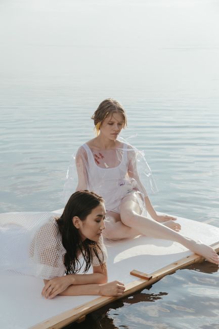 Two women sitting on a raft, enjoying a peaceful day by the ocean.