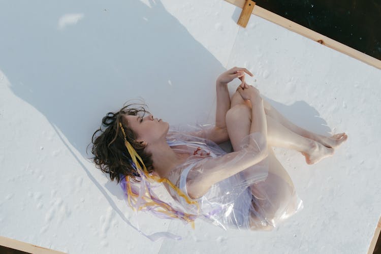 A Woman In White Swimsuit Lying On The Raft