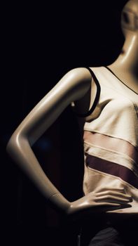 Close-up of a mannequin in a stylish tank top against a dark background.