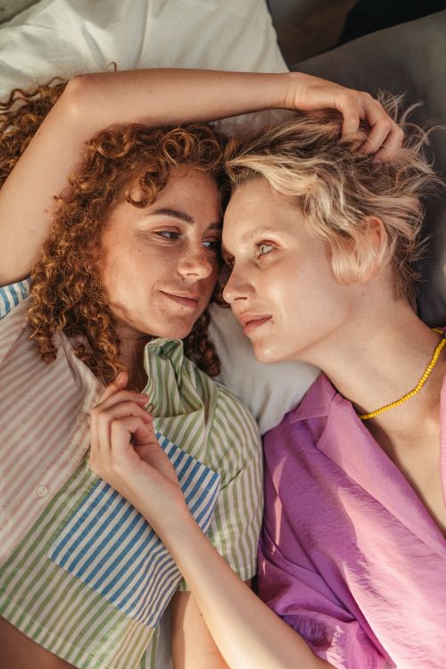 Free Two women lying together, embracing love and intimacy indoors. Stock Photo