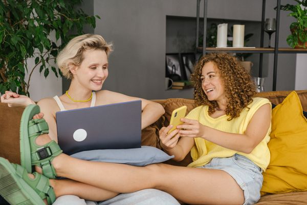 Two people browsing on a sofa, photo by SHVETS production on Pexels