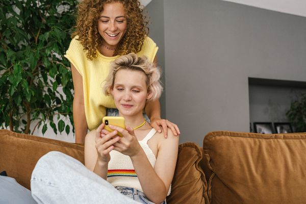 Two people sharing a phone screen at home — photo by SHVETS production on Pexels