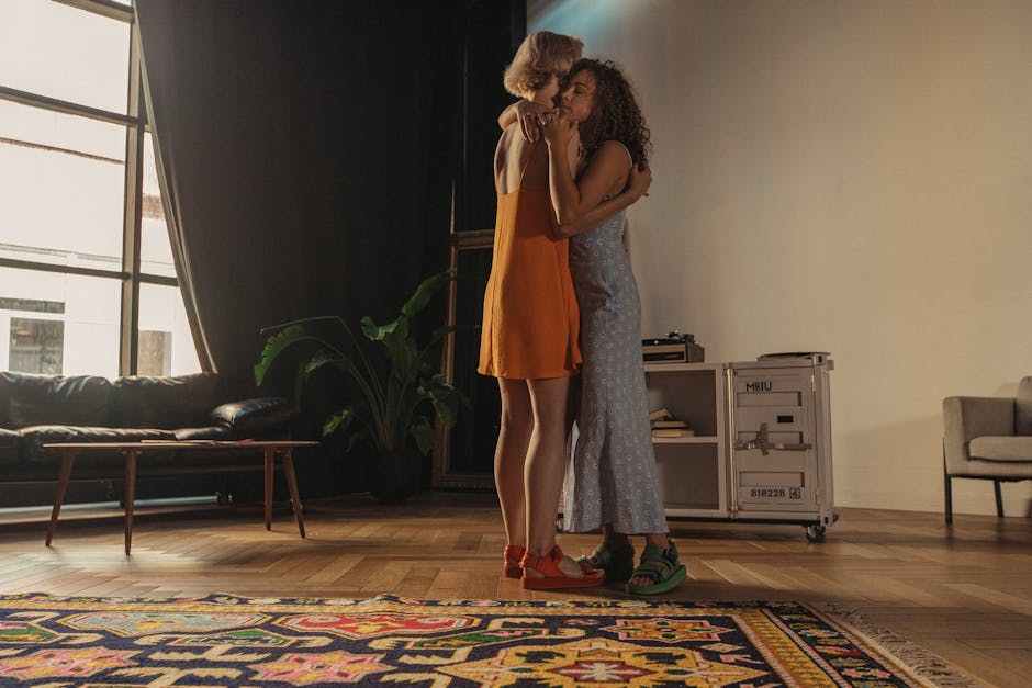 A tender moment of love between two women embracing in a warm, cozy indoor setting.