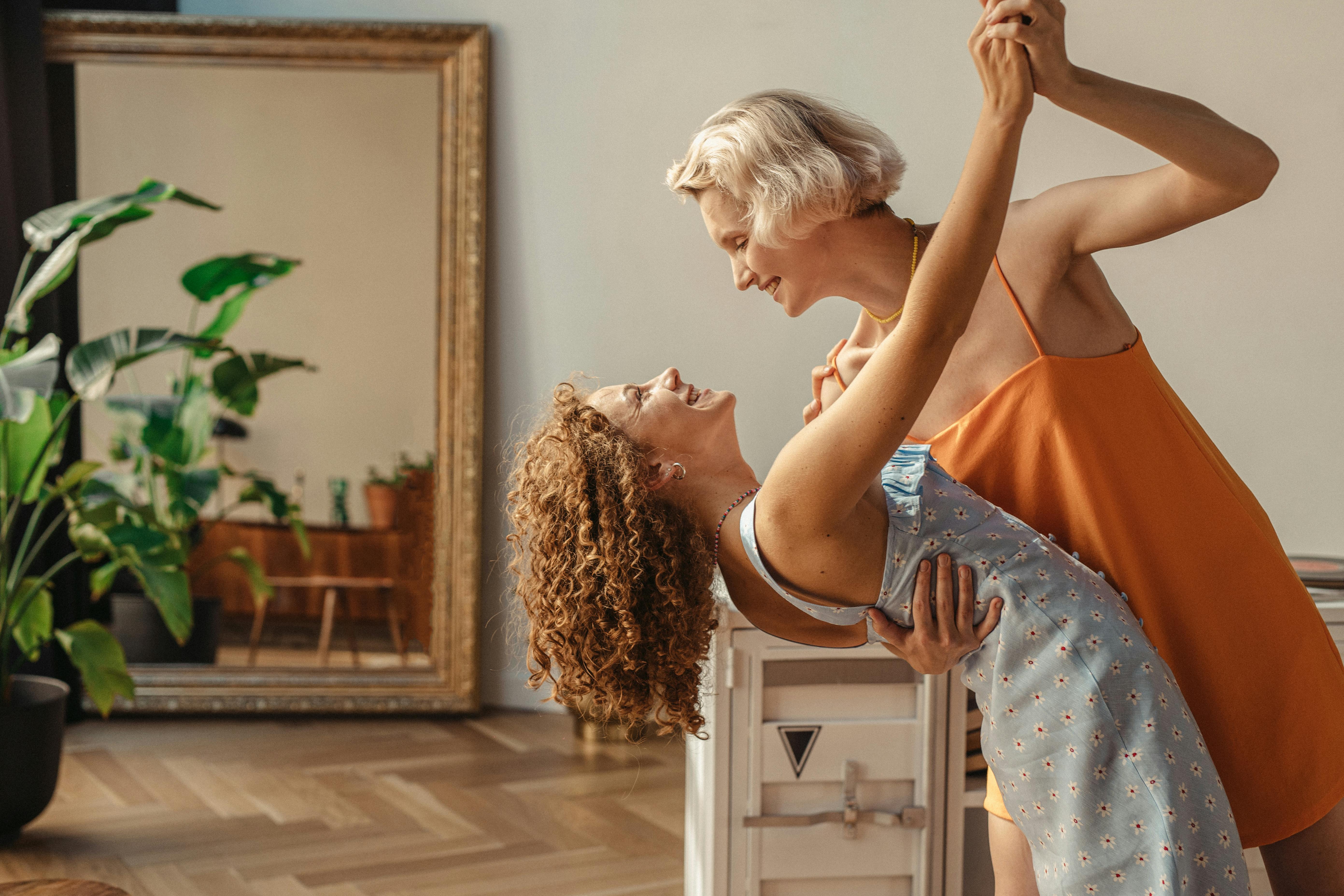 happy women dancing together indoors