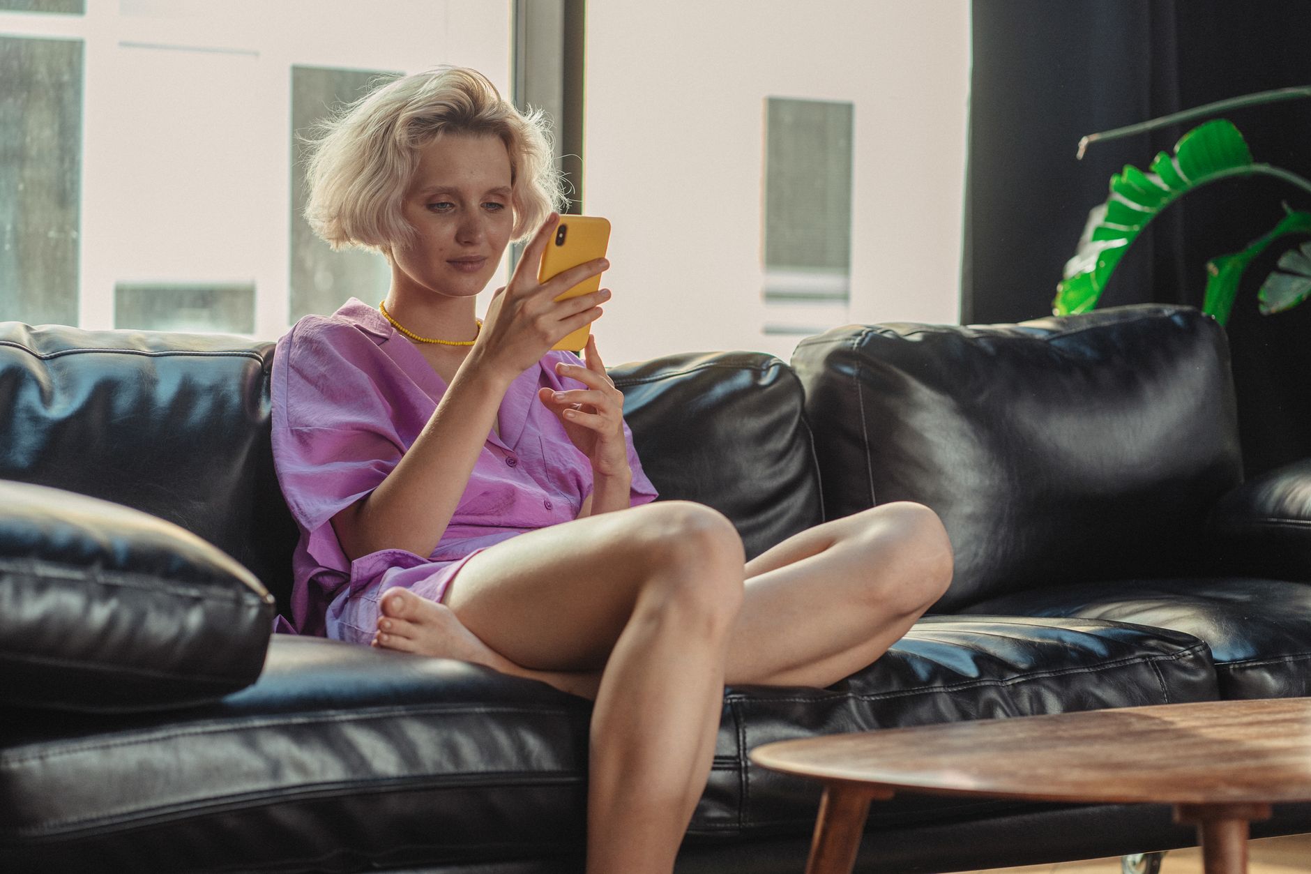 Debunked Myths about Used iPhones - The Top 5 1 Woman in Pink Shirt Sitting on Black Leather Couch