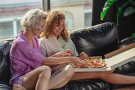 Woman in Purple Dress Sitting on Black Leather Couch