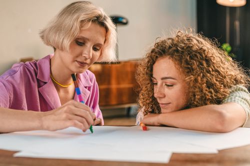 Free Two women enjoying a creative writing session at home, capturing friendship and leisure. Stock Photo