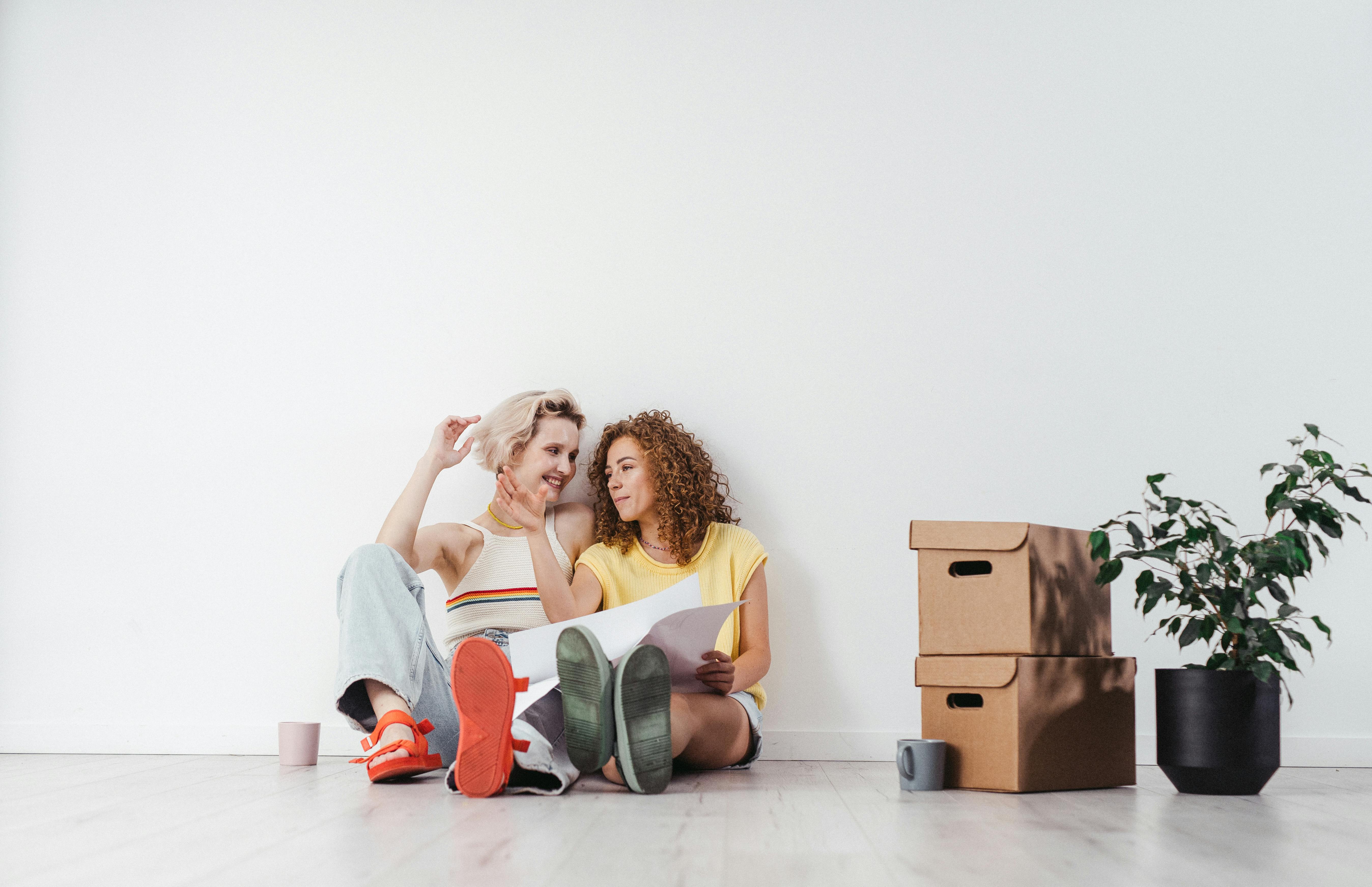 couple of women sitting on a ground