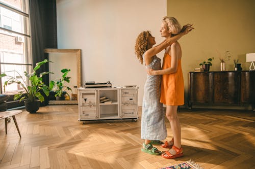 A Couple in Dresses Dancing in the Living Room