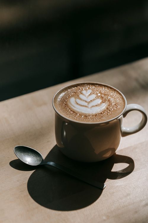 Free Elegant cappuccino with latte art design in a cozy ambient light setting. Stock Photo