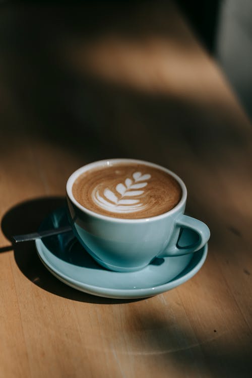 Coffee With Latte Art On Blue Ceramic Cup With Saucer