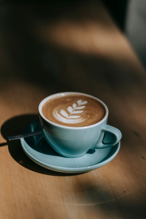 Free A cup of coffee with delicate floral latte art in a cozy indoor setting. Stock Photo