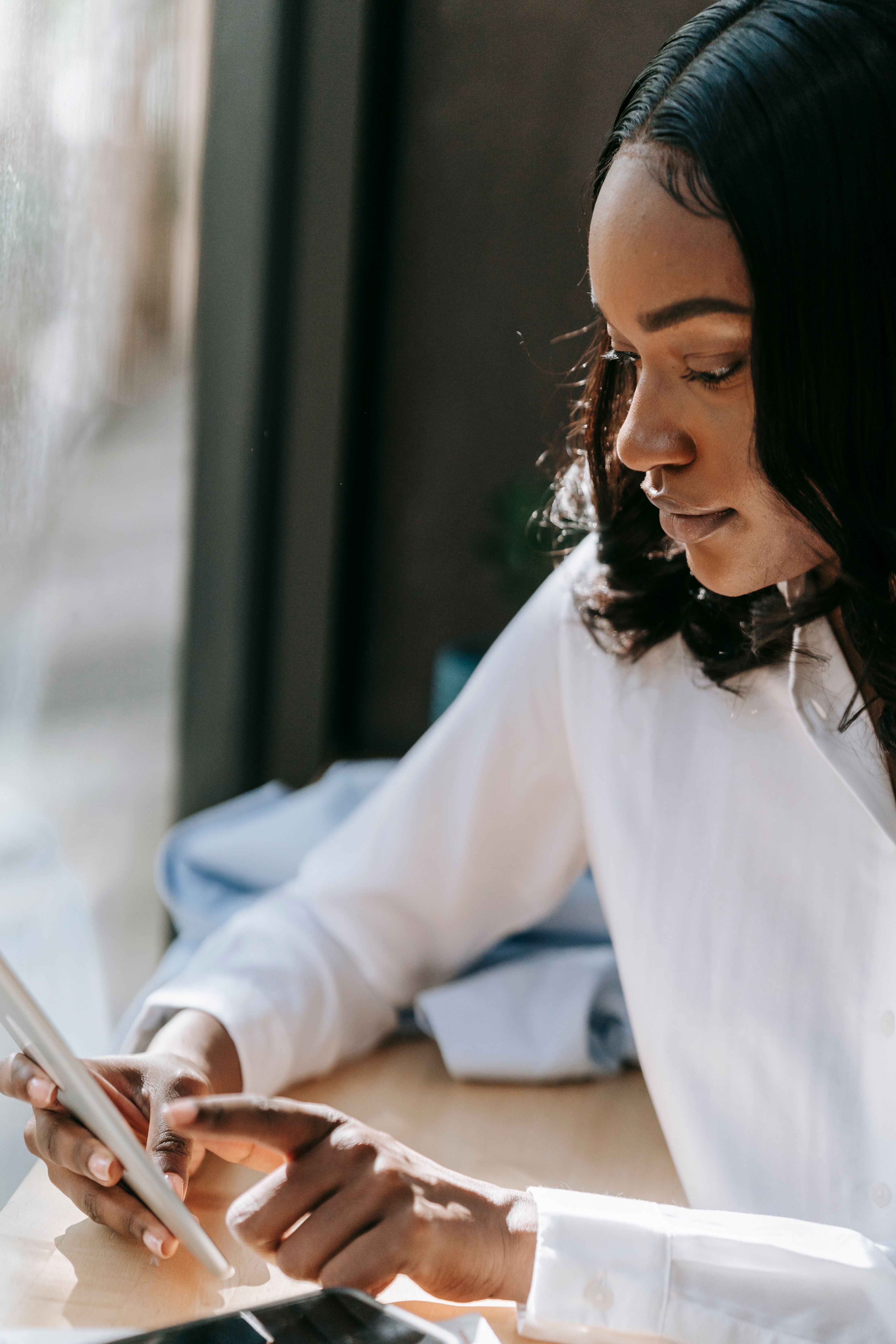 Selective Focus Photo of a Woman in a White Dress Shirt Using Her Cell Phone