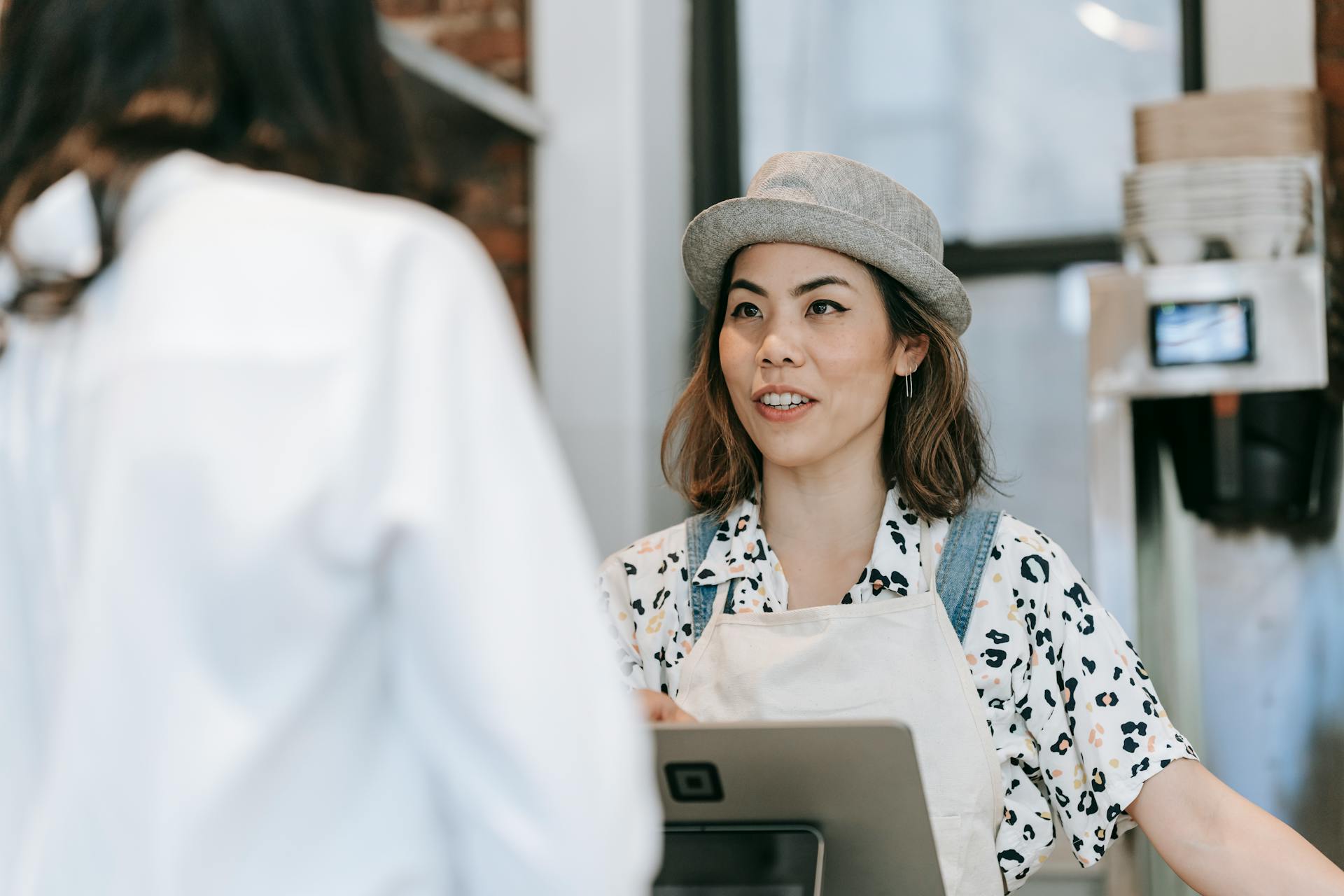 A Woman at a Counter Talking to a Customer