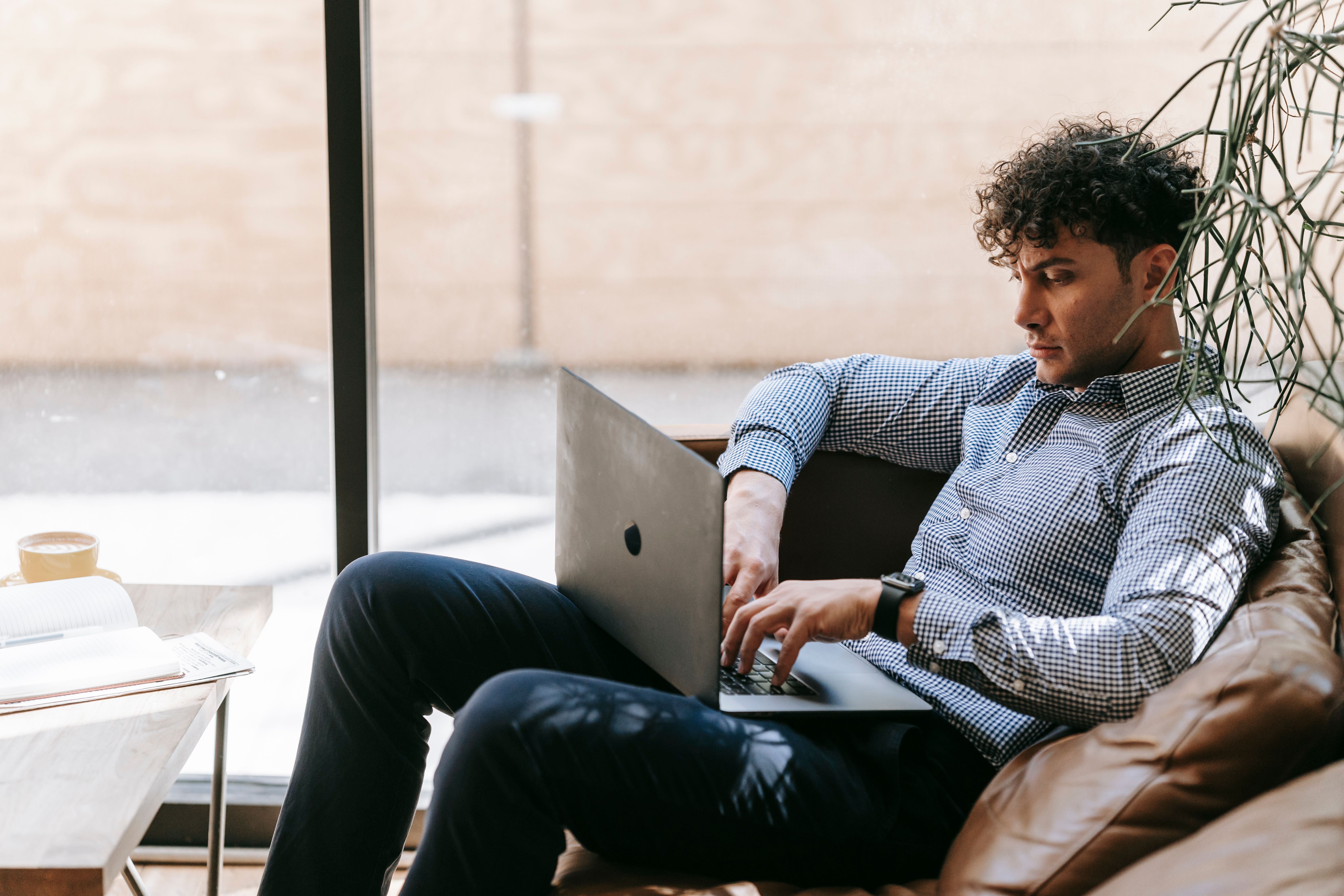 Hispanic man on laptop comparing car insurance quotes at home in Florida