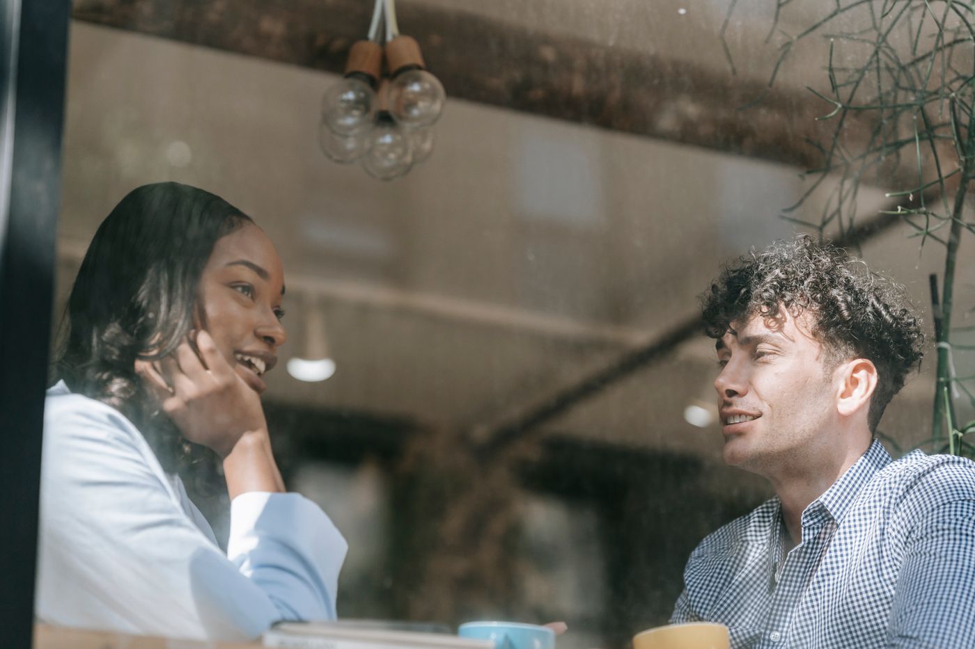 Two people talking through a cafe window