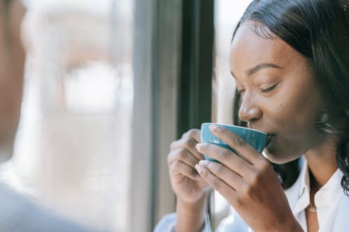 Woman Drinking Coffee from a Blue Ceramic Cup