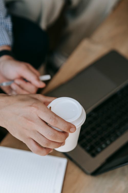 A Person Holding a Beverage in a Disposable Cup