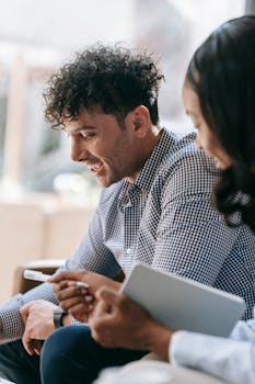 Two adults having a lively discussion in a bright cafe setting.