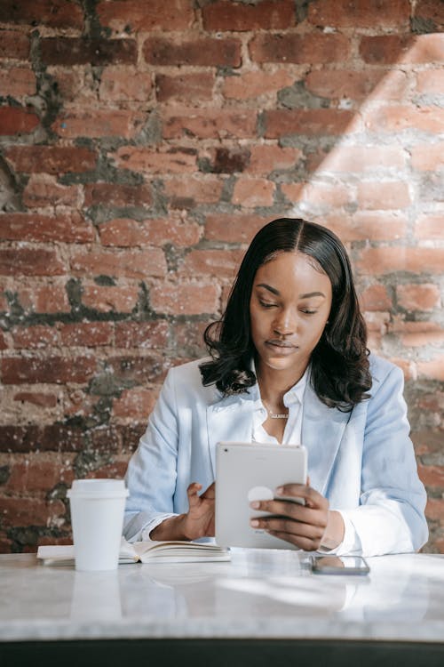 Woman in Light Blue Blazer using Tablet