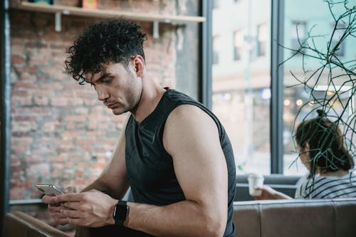 A Man Using a Cellphone Indoors