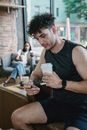 Man in Black Tank Top using Phone