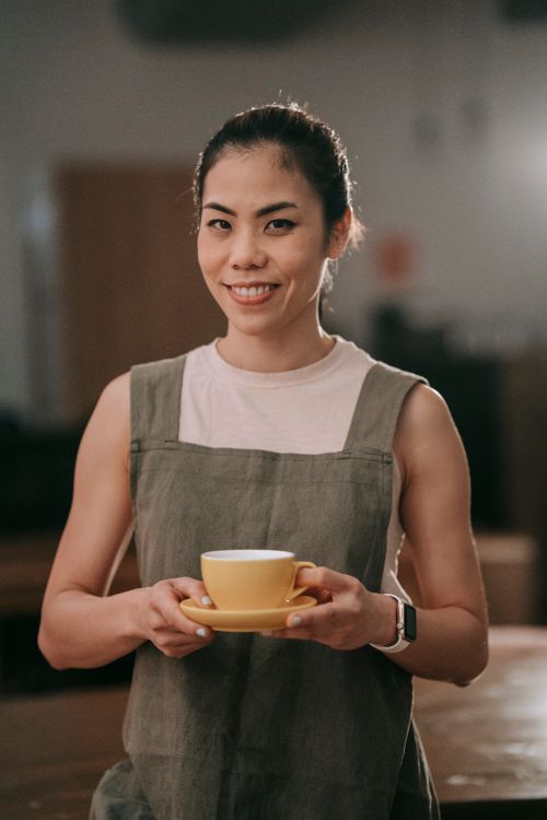 Smiling Woman Holding a Cup of Coffee · Free Stock Photo