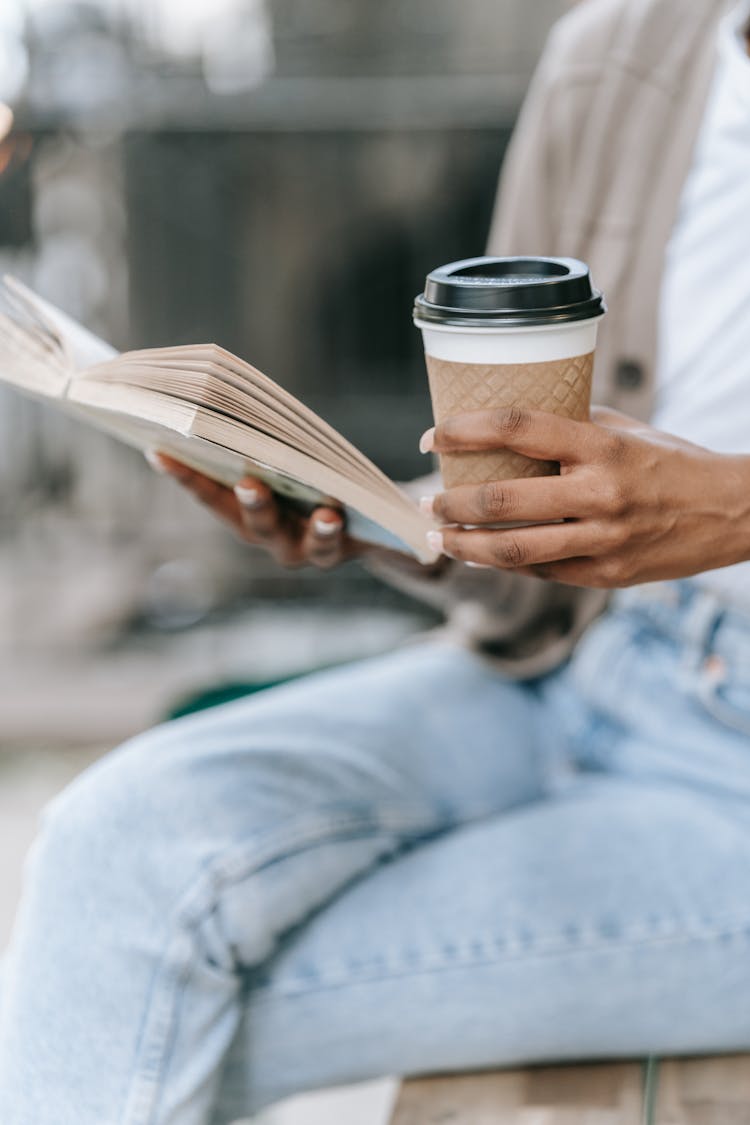 Woman Reading Book And Holding Coffee