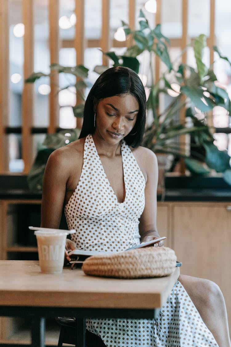 A Woman Reading A Book At A Coffee Shop