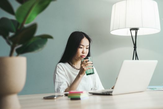 Person sipping water at their desk during the morning