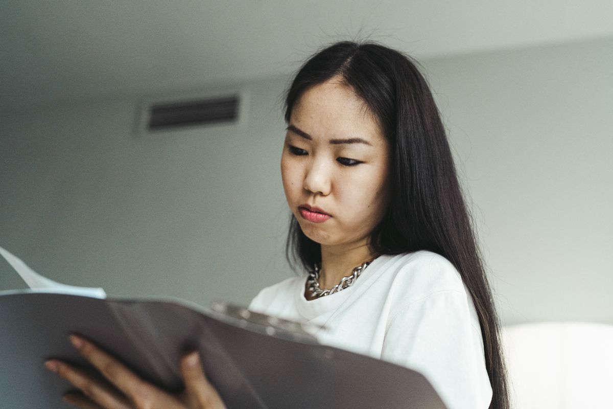 Phụ nữ châu Á kiểm tra hồ sơ và tài liệu để chuẩn bị khiếu nại