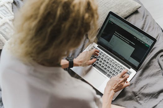 Woman using laptop in bed, embodying remote work lifestyle. Perfect for digital nomad concepts.