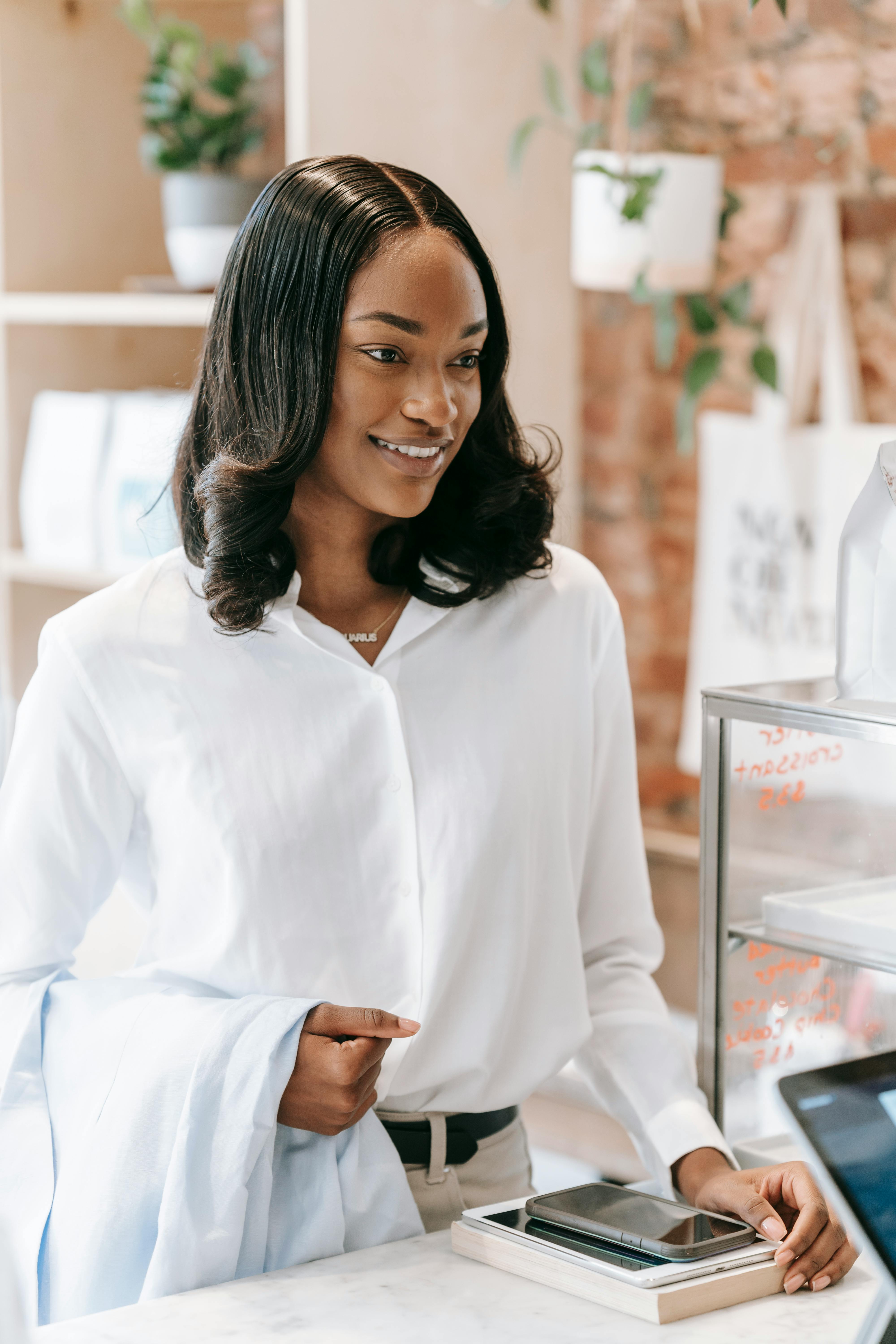 woman in white long sleeve shirt standing near a counter