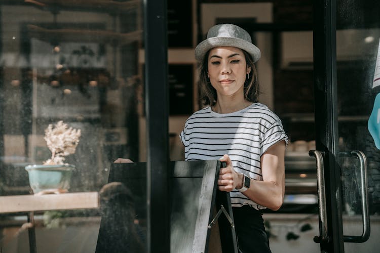 Woman In Hat Opening Coffee Shop