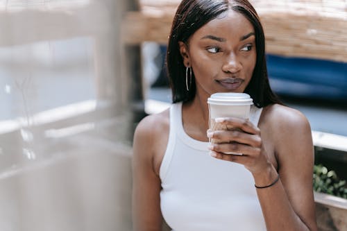 Woman in White Tank Top Drinking from White Plastic Cup