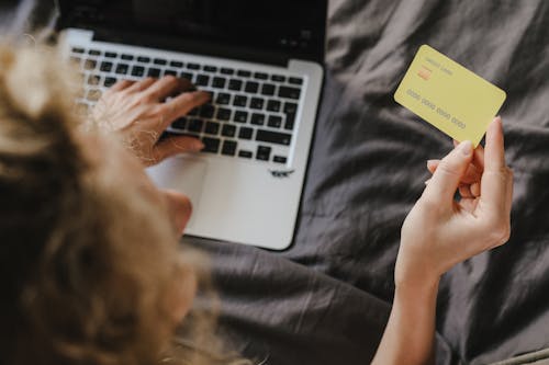 Person Holding a Yellow Credit Card