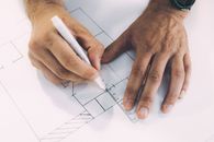Close Up Photo of Person Drawing Lines on Paper with Ruler and Pen