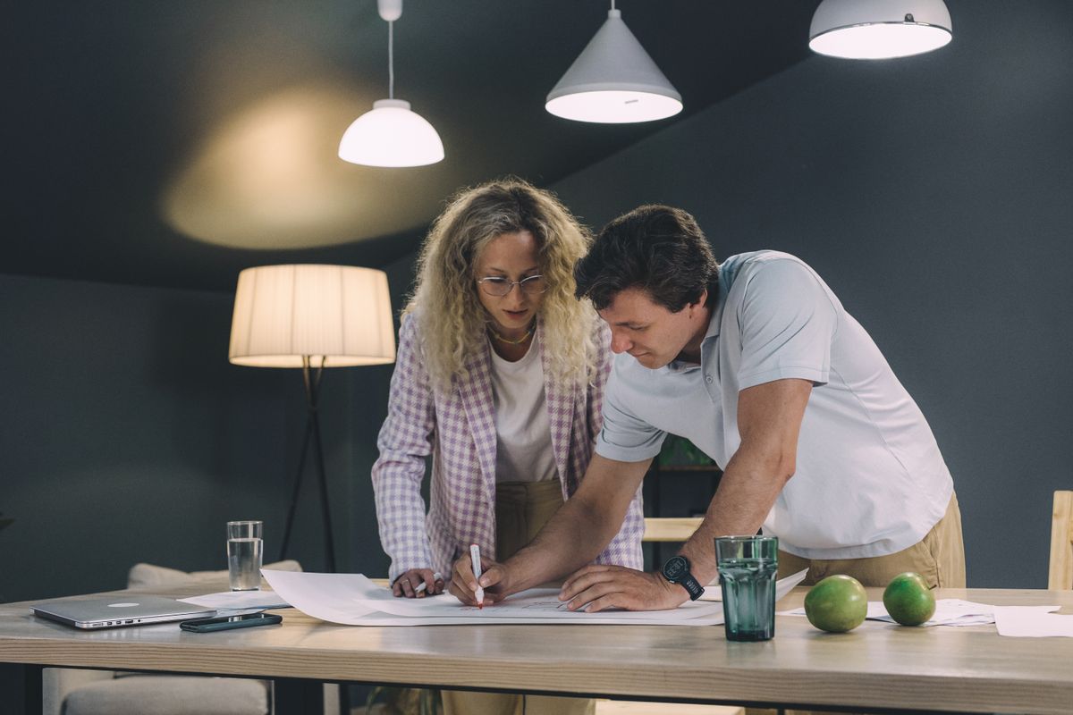 Two professionals collaborating over a project in a modern office