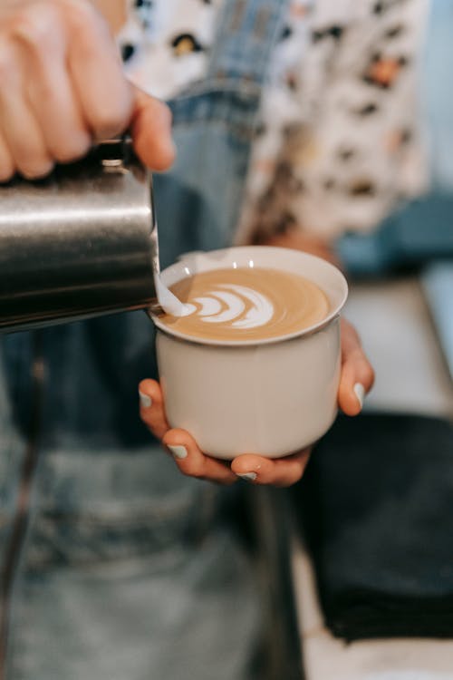 A Person Holding White Ceramic Cup With Cappuccino